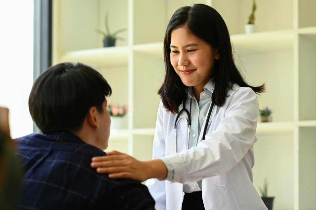 Caring doctor touching patient shoulder, giving empathy, comfort, psychological support.